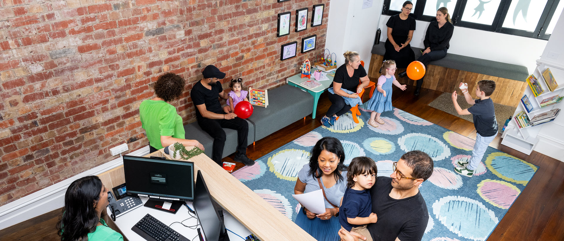 Children playing, their families and staff in the reception area at Ascot Vale Paediatrics